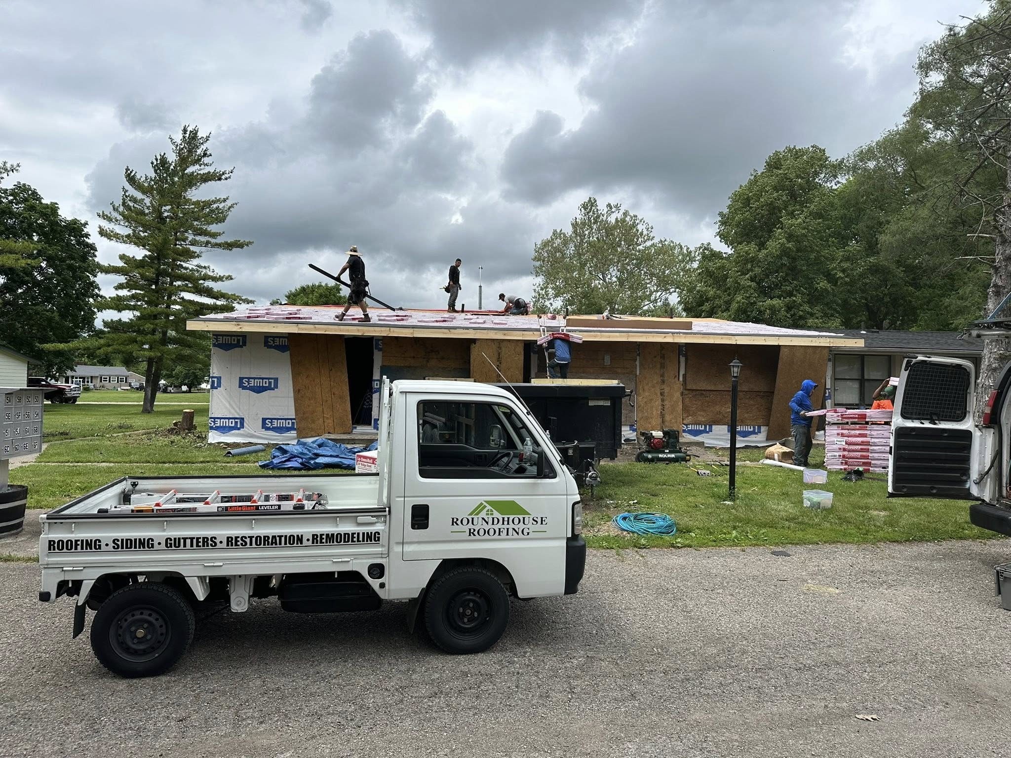 The Roundhouse Roofing crew and branded truck on a job site